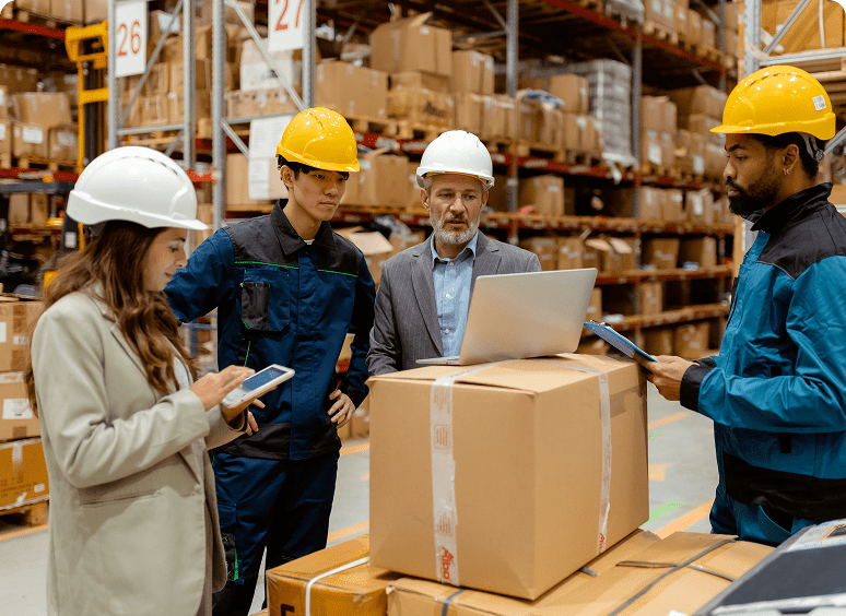 Warehouse team meeting around stacked boxes