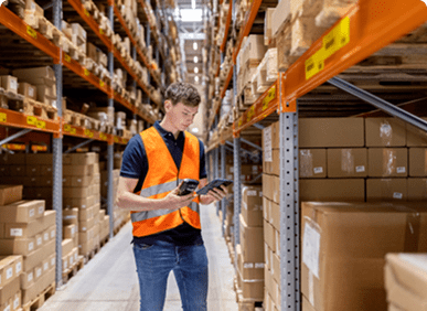 Worker inspecting stock in warehouse aisle