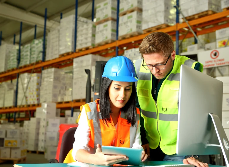 Warehouse workers reviewing inventory on tablet